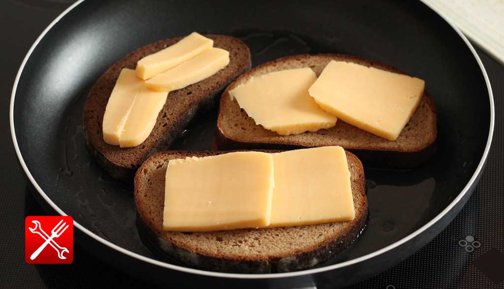 Кусочки хлеба на сковороде с сыром на них